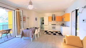 Un appartement moderne comprenant un coin repas, une cuisine et un balcon.