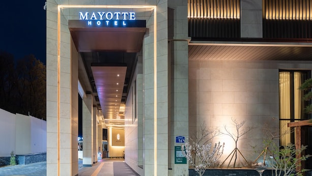 The Mayotte Hotel entrance with a modern design, a clear pathway leading inside, and a sign indicating a parking area. - Uiwang Hotel Mayotte (Uiwang)
