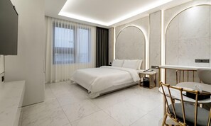 A modern hotel room with a large bed, a desk, and a chair. - Uiwang Hotel Mayotte (Uiwang)