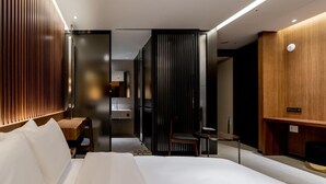 A modern hotel room with a large bed, a wooden desk, a small table, and a mirror. - Uiwang Hotel Mayotte (Uiwang)