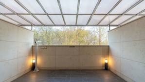 A covered outdoor area with tiled flooring and two wall-mounted lights. - Uiwang Hotel Mayotte (Uiwang)