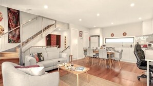 A modern living room with a grey sofa, a coffee table, and a staircase leading to another level.