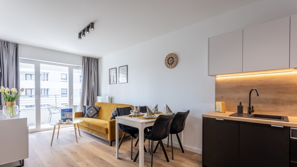 A modern living space with a dining area, kitchen, and large windows. - Vacation apartment by the sea, vacation on the island of Usedom, Apartment SUN TOWERS B42 (Świnoujście)