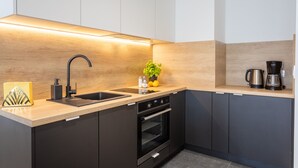 A modern kitchen with a built-in oven, a sink, and a coffee maker. - Vacation apartment by the sea, vacation on the island of Usedom, Apartment SUN TOWERS B42 (Świnoujście)