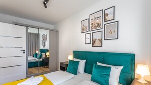 A hotel room with a large bed, a mirror, a wardrobe, and a nightstand with a lamp. - Vacation apartment by the sea, vacation on the island of Usedom, Apartment SUN TOWERS B42 (Świnoujście)