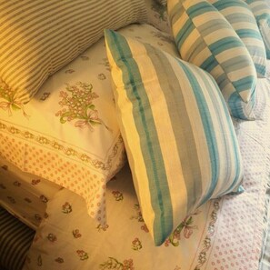 A bed with floral patterned bedding and striped pillows. - Flower House (San Macario in Piano (LU))
