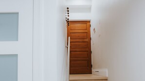 Un escalier avec des marches en bois et une porte blanche dotée de panneaux en verre dépoli.