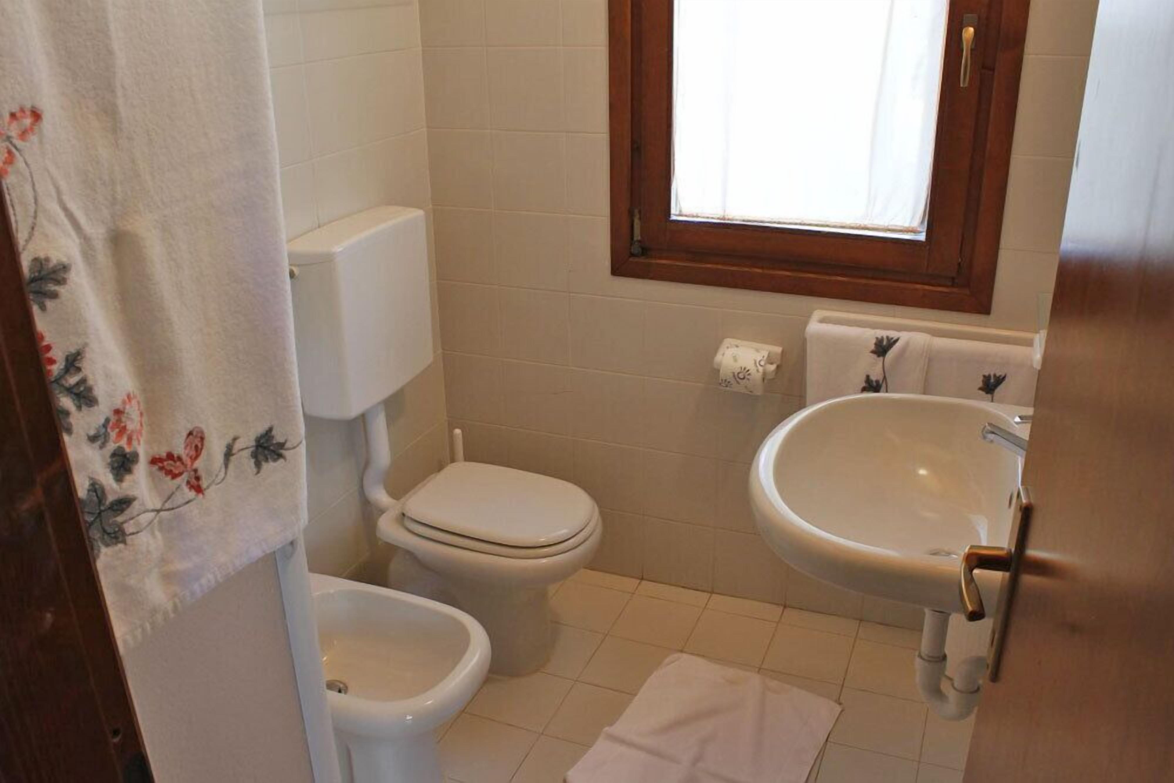 Ein kleines Badezimmer mit Toilette, Bidet und Waschbecken.