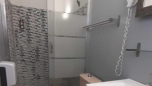 Un baño con ducha, inodoro y lavamanos.