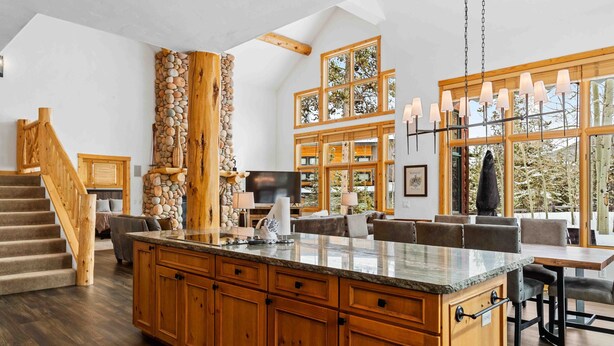A spacious kitchen with a large island, wooden cabinets, and a stone accent wall. - Private Waterdance Home with all the Amenities!! (Frisco)