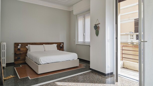 A bedroom with a bed, a radiator, a window, and a door leading to an outdoor area. - Beauty Design in the Center by Wonderful Italy (Genoa)