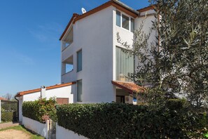 Un bâtiment à deux étages, avec une façade blanche, un toit rouge et une antenne parabolique sur le toit.