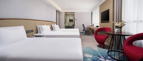 Une chambre d’hôtel avec deux lits, un bureau, une chaise et un téléviseur.