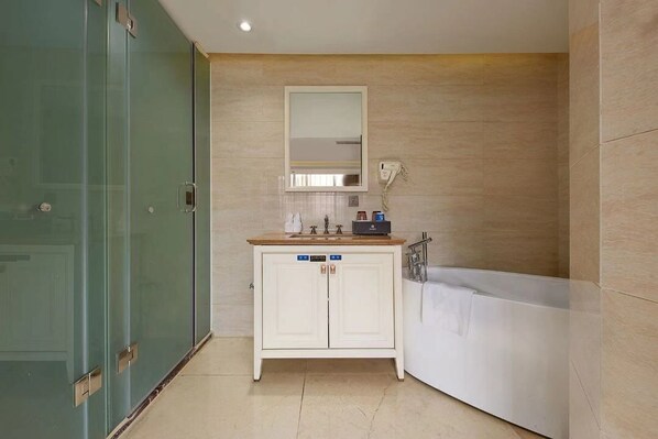 A bathroom with a glass shower enclosure, a white vanity with a mirror, and a white bathtub.