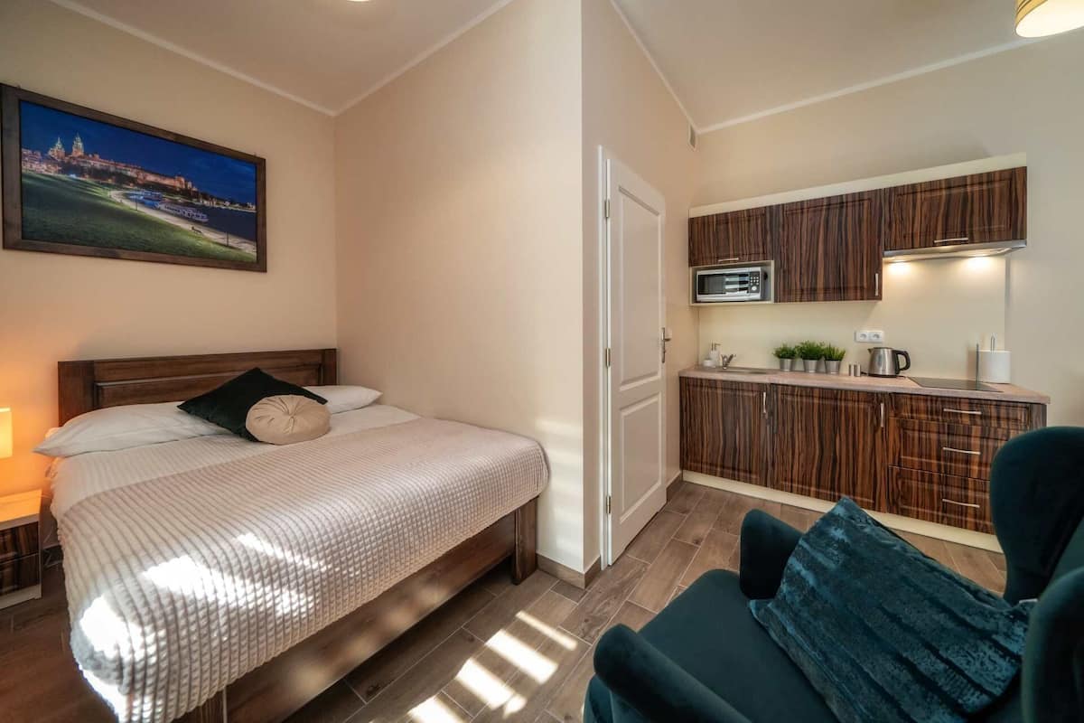 A bedroom with a bed, a nightstand, a TV, and a view of a cityscape.