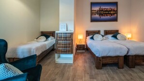A hotel room with two single beds, a wooden cabinet, a chair, and a framed picture on the wall. - Apartments 17 Szewska (Kraków)