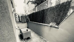 A narrow outdoor space with a wicker chair and a potted plant. - Home Vatican Oasis (Roma)