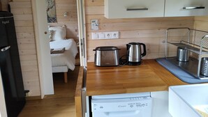 Une petite cuisine équipée d’un grille-pain, d’une bouilloire et d’un égouttoir à vaisselle.