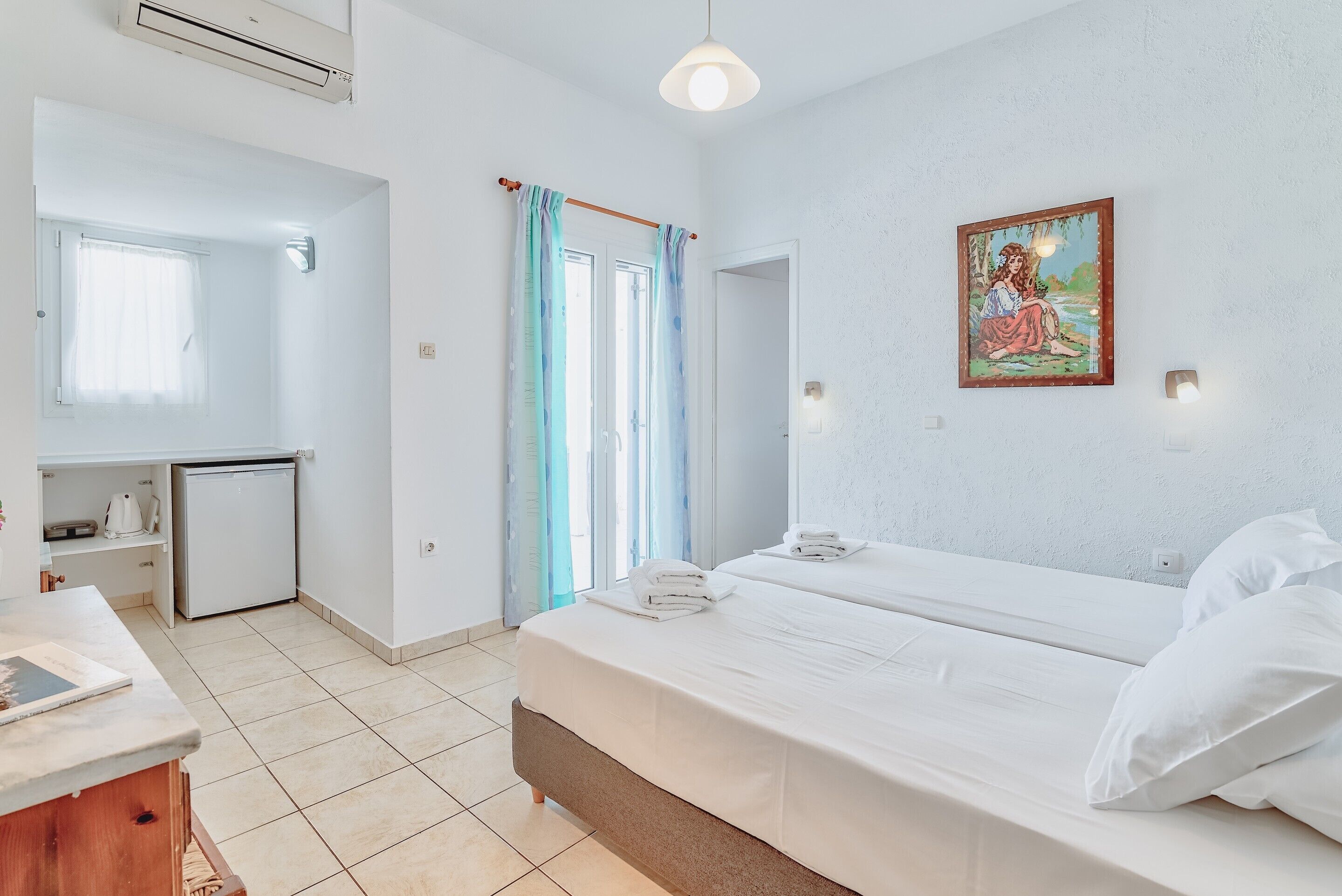 Un dormitorio con una cama, un escritorio y un refrigerador pequeño.
