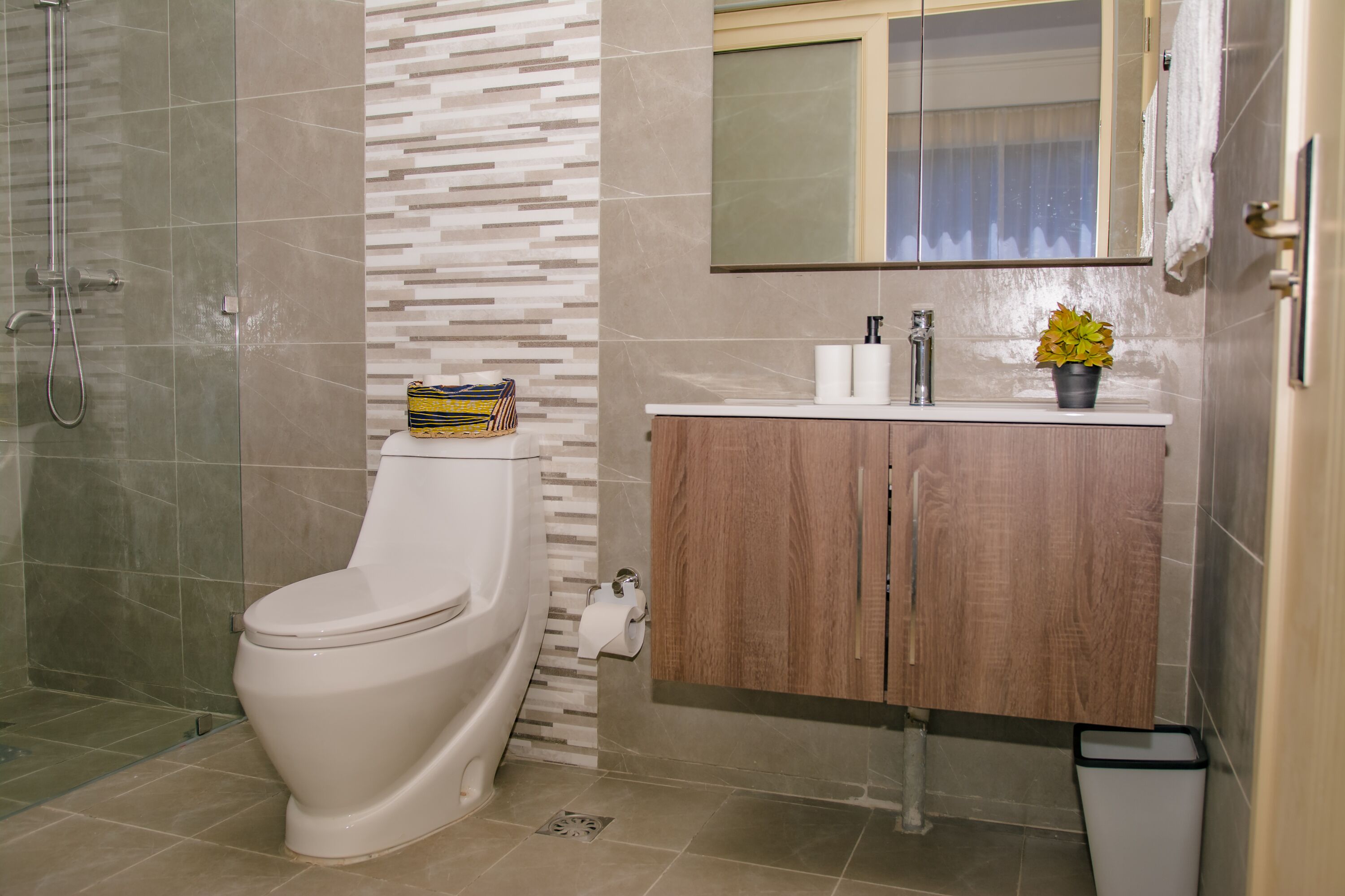 Un bagno con toilette, doccia, lavandino e specchio.