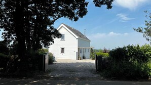 A white house with a gravel driveway and a wooden gate. - Spires (Truro)