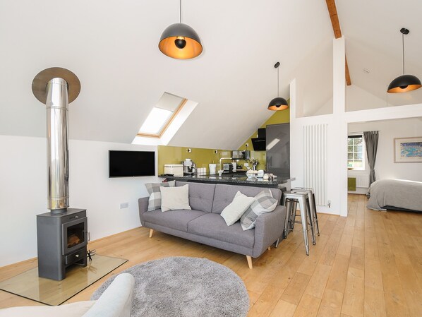 Un loft moderno con cocina, sala de estar y chimenea.