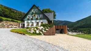 Un chalet traditionnel avec une façade en pierre, un escalier en bois et une extension moderne.