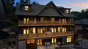A multi-story building with a dark exterior, wooden balconies, and multiple windows.