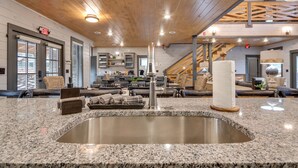A modern lobby with a granite countertop, a sink, and a staircase leading to an upper level.