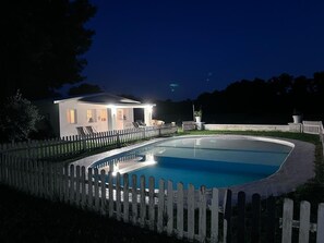 Una piscina con cubierta de madera y valla de piquetes blancos.