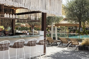 A poolside bar area with wicker chairs, a bar counter, and a view of the pool. - Pereh Mountain Resort  (Katzrin)