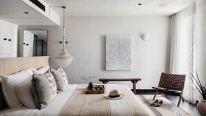 A bedroom with a bed, bedside table, chair, and artwork on the wall. - Pereh Mountain Resort  (Katzrin)