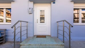 A building entrance with a white door, metal handrails, and a number '9' sign. - Klio's cozy house city center (Heraklion)