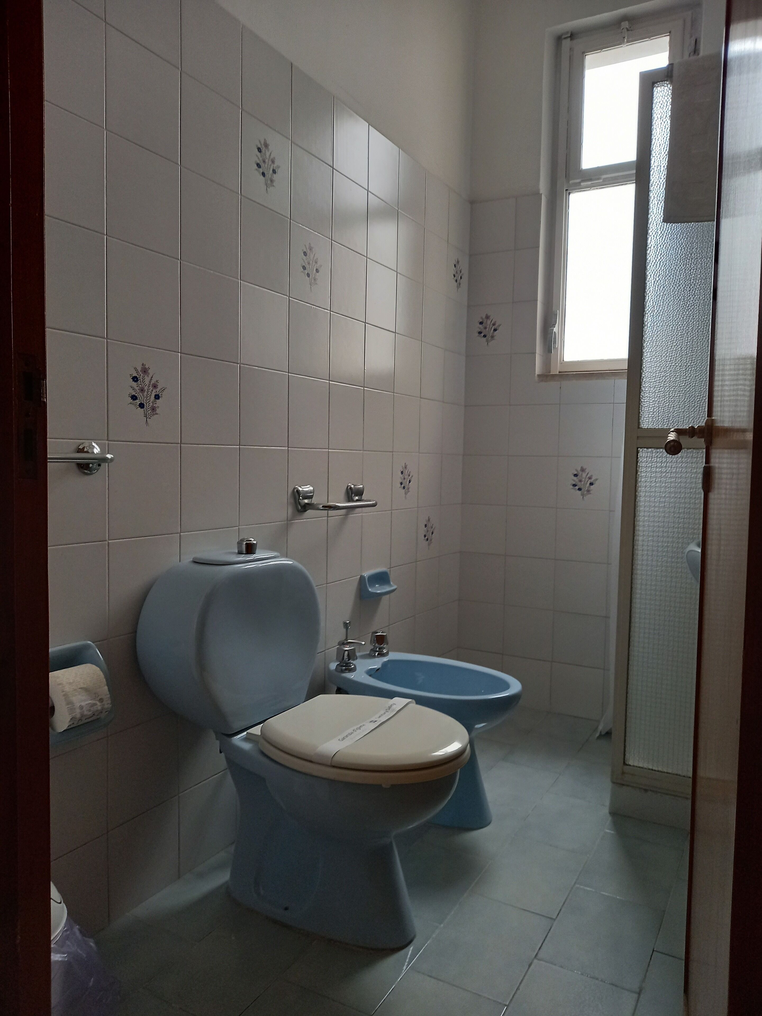 Une salle de bain comprenant des toilettes, un bidet et un espace douche.