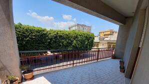 A balcony with tiled flooring, potted plants, and a metal railing. - Vacation house, sleeps 6, in Noto 500 mt from the center. (Noto)