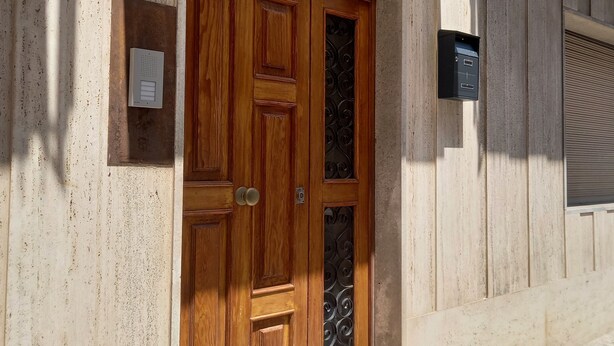 A wooden double door with a glass panel, a mailbox, and a metal mailbox on the wall. - Vacation house, sleeps 6, in Noto 500 mt from the center. (Noto)