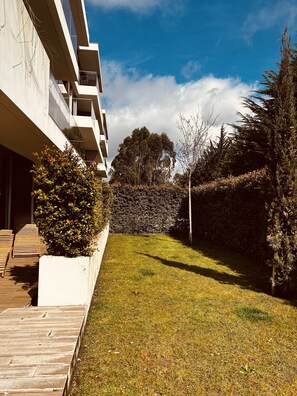 Un bâtiment moderne doté d’un toit plat et de grandes fenêtres, entouré d’une pelouse bien entretenue et d’arbres matures.