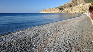 A pebble beach with a clear view of the sea and a mountain in the background. - 3-room House With Sea View (Ierapetra)