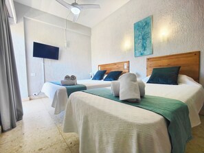 Superior driepersoonskamer | Bedden met traagschuimmatrassen, een bureau, een laptopwerkplek