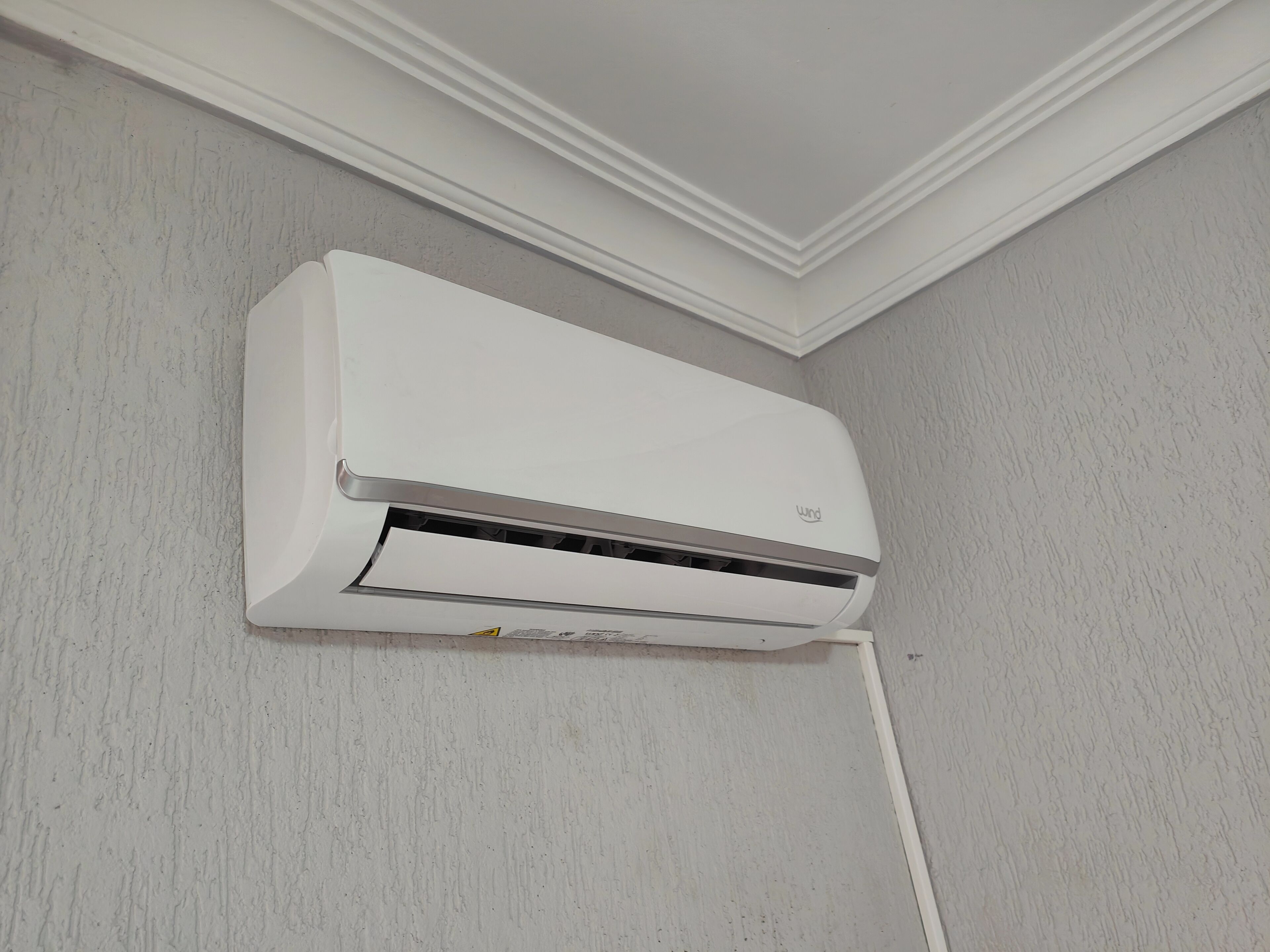 A white wall-mounted air conditioning unit with a visible brand logo and a control panel.