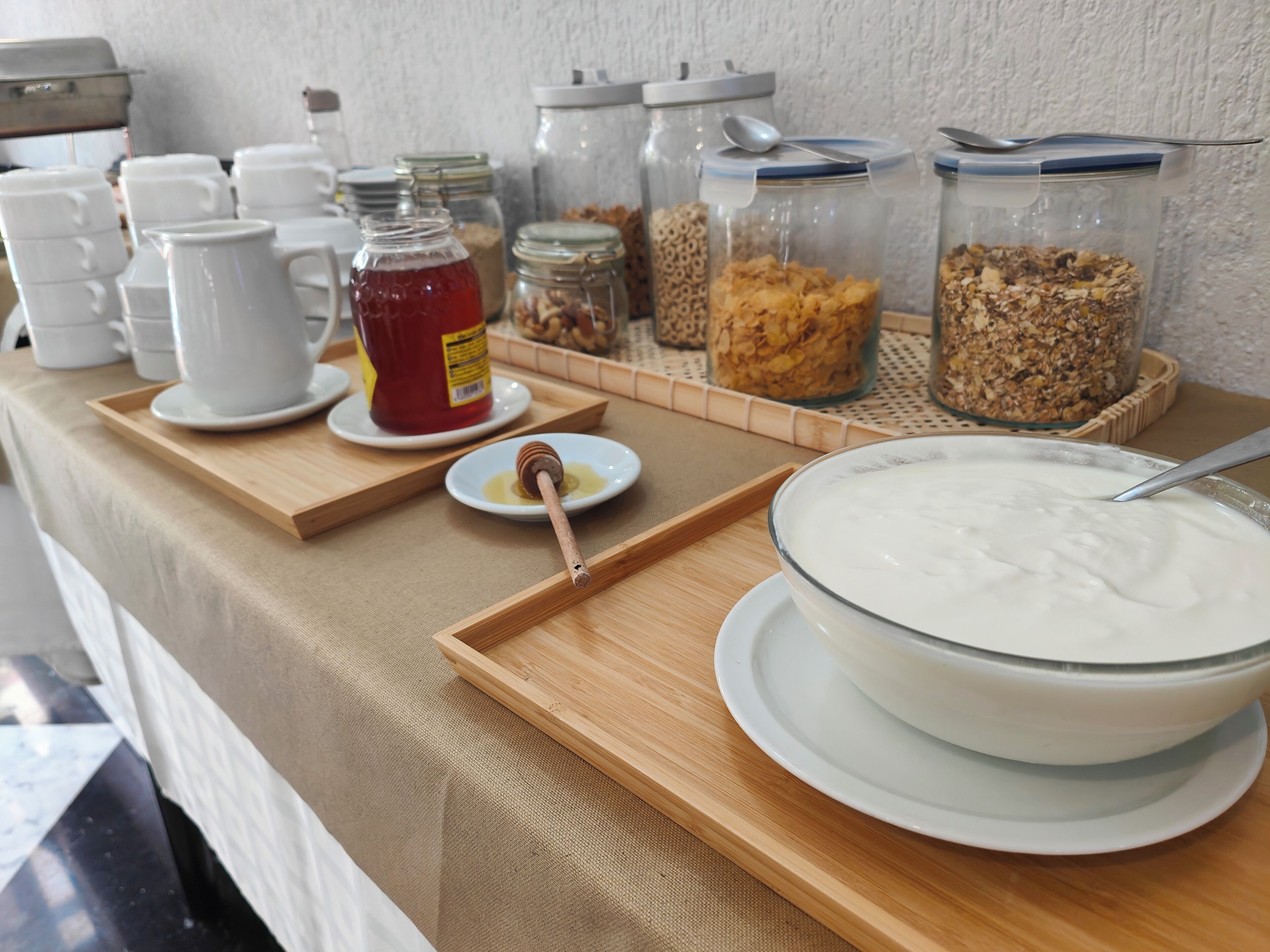 A breakfast buffet with various food items and utensils.