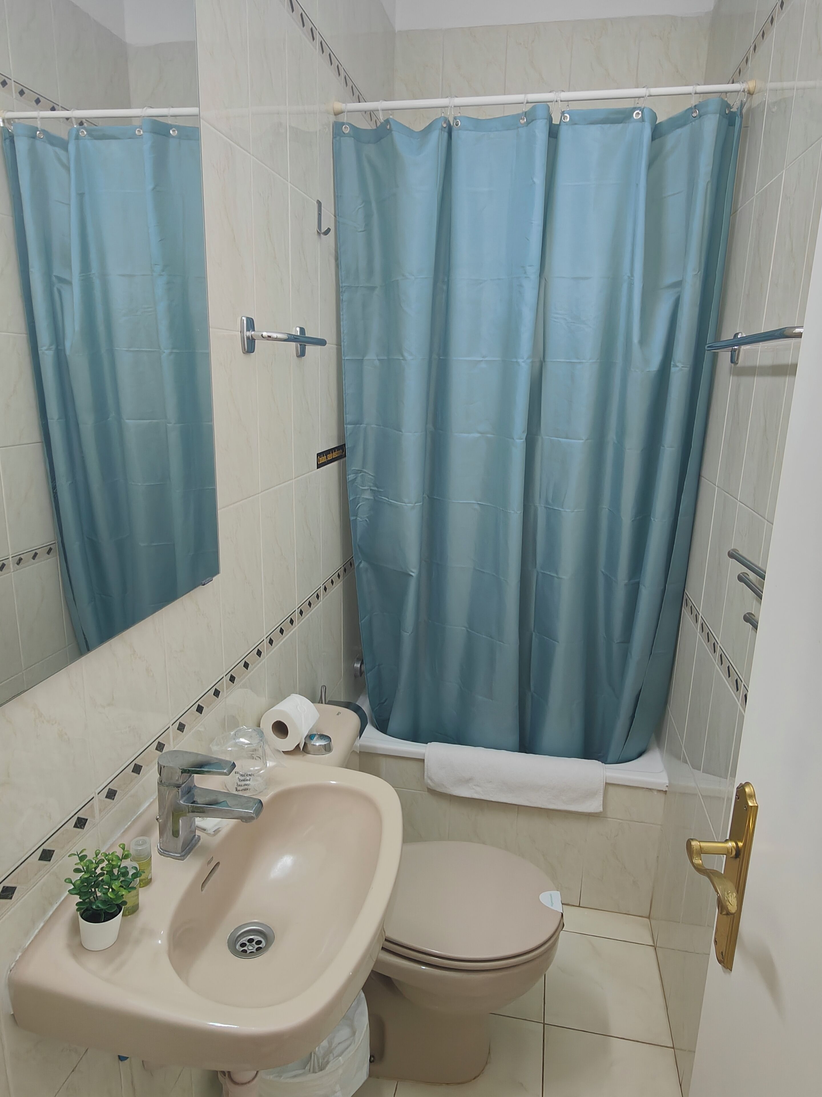 Un baño con lavamanos, inodoro y cortina de ducha.
