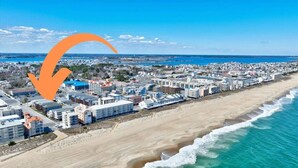 Un paysage urbain côtier avec une zone hôtelière en bord de mer, comprenant des bâtiments, une plage et l’océan.