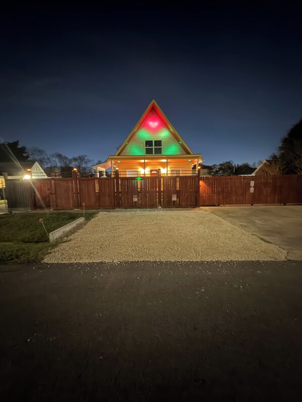 Une maison avec un toit triangulaire et une véranda.