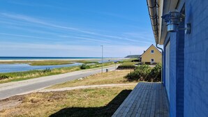 A coastal road leading to a yellow house with a blue exterior wall. - Large holiday house with great seaview - sauna and hottub (Glesborg, Bønnerup Strand)