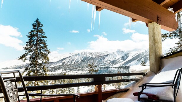 A wooden balcony with a view of snow-covered mountains and trees. - Deluxe Home, Great Views! Private Gas Grill & Washer/Dryer, Near Lakes Basin (Mammoth Lakes)