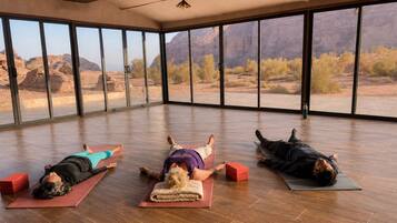 A spacious room with large windows offering a view of a desert landscape.
