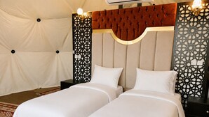 A double bed with a tufted headboard, two bedside tables, and decorative wall panels. - Hasan Zawaideh Luxury Camp 2 (Wadi Rum)