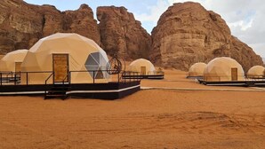Paisaje desértico con varias tiendas en forma de cúpula dispuestas en filas.