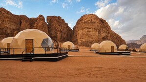 A desert landscape with multiple dome-shaped yurts arranged in rows. - Hasan Zawaideh Luxury Camp 2 (Wadi Rum)